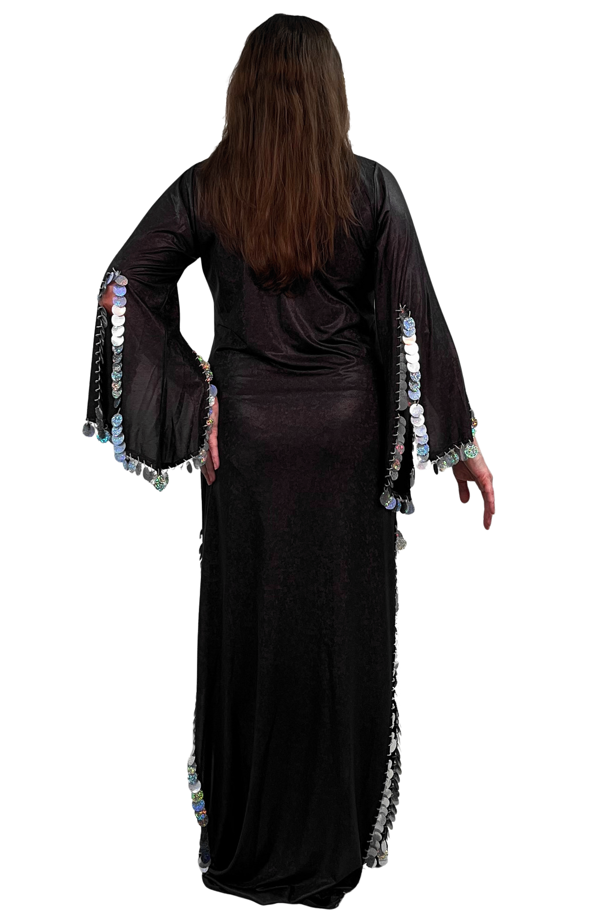 A woman viewed from the back wearing a long black dress with wide bell sleeves decorated with rows of silver paillette trim, standing against a plain white background.
