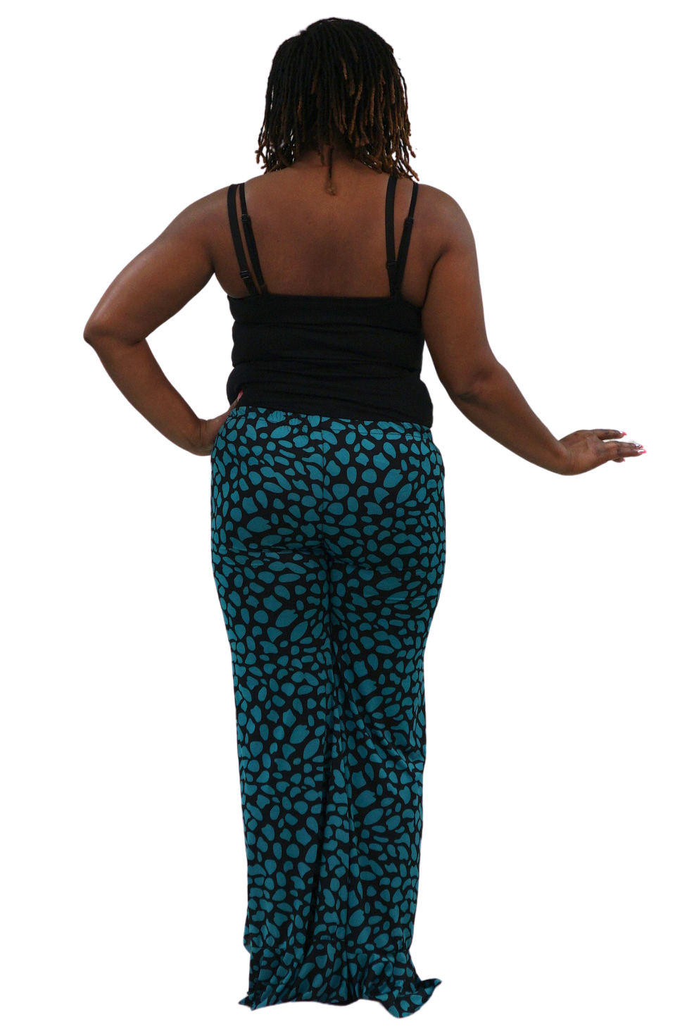 A woman shown from the back wearing a black spaghetti-strap top and teal pants with a black abstract spotted pattern, isolated on a white background.