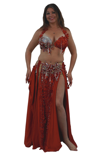 Woman wearing a red belly dancing costume with sequins on a white background