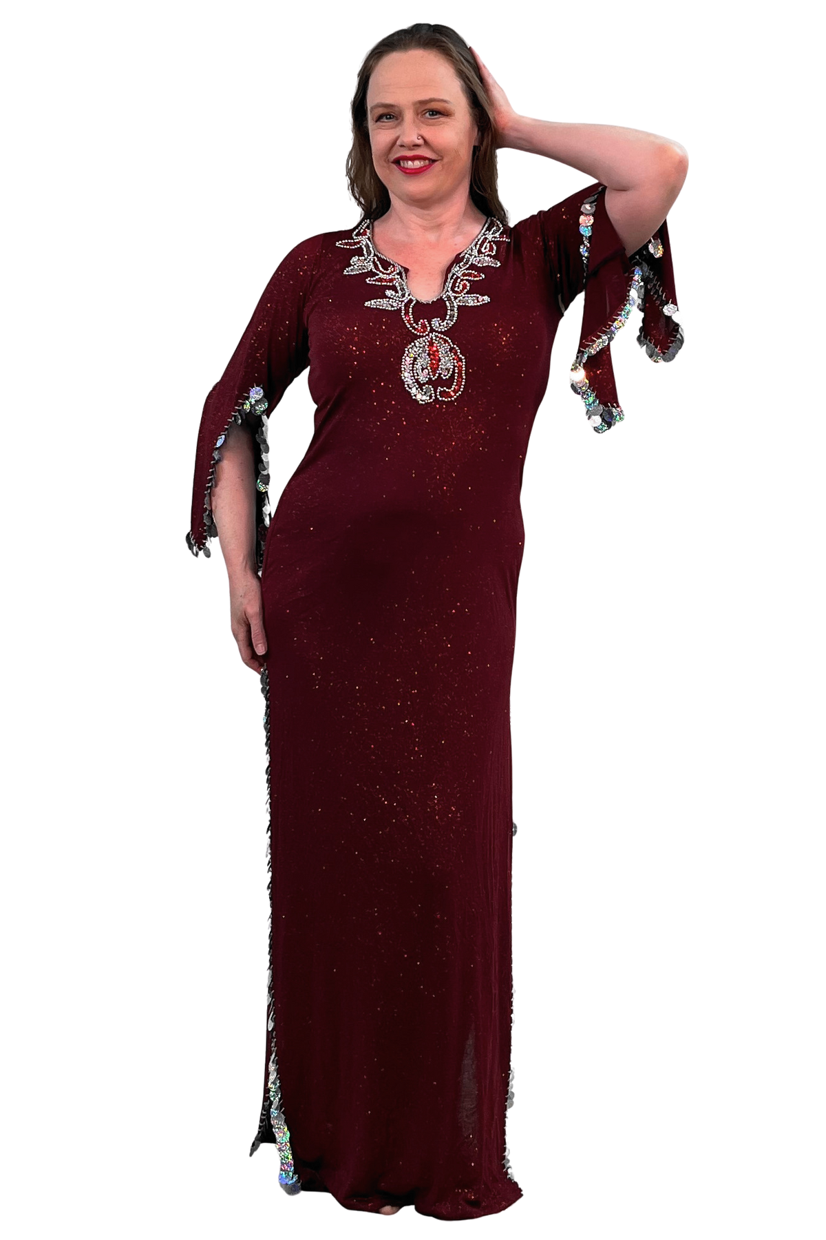 A woman modeling a floor-length maroon maxi dress with silver sequins, a V-neckline, and wide flared sleeves with silver trim, set against a plain white background.