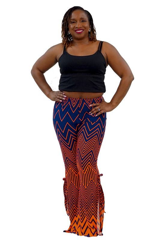 A woman modeling a black tank top and high-waisted flared pants with a bold blue, orange, and black zigzag pattern, set against a plain white background.