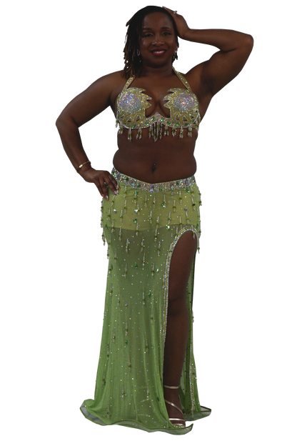 Woman wearing a green beaded bellydance costume on a white background