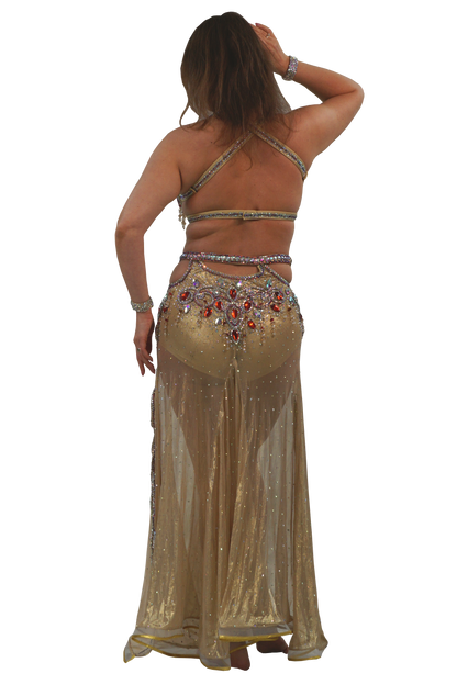 Woman wearing a gold belly dancing costume with intricate designs on a white background