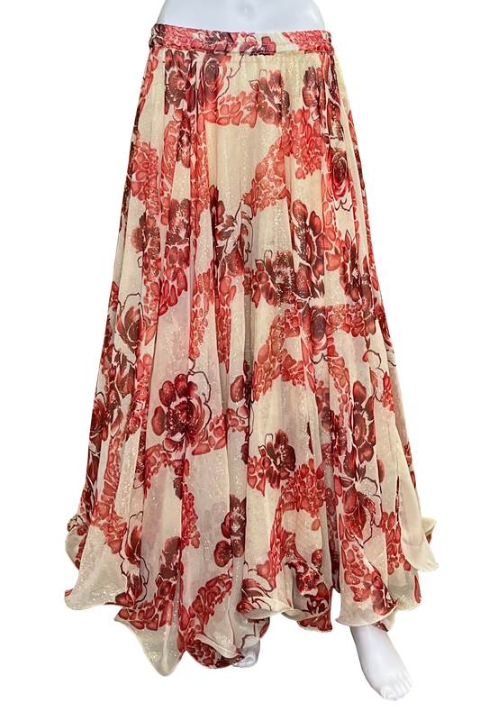 A flowing maxi skirt with a red and brown floral pattern on a glittery beige base, displayed on a white mannequin against a white background.
