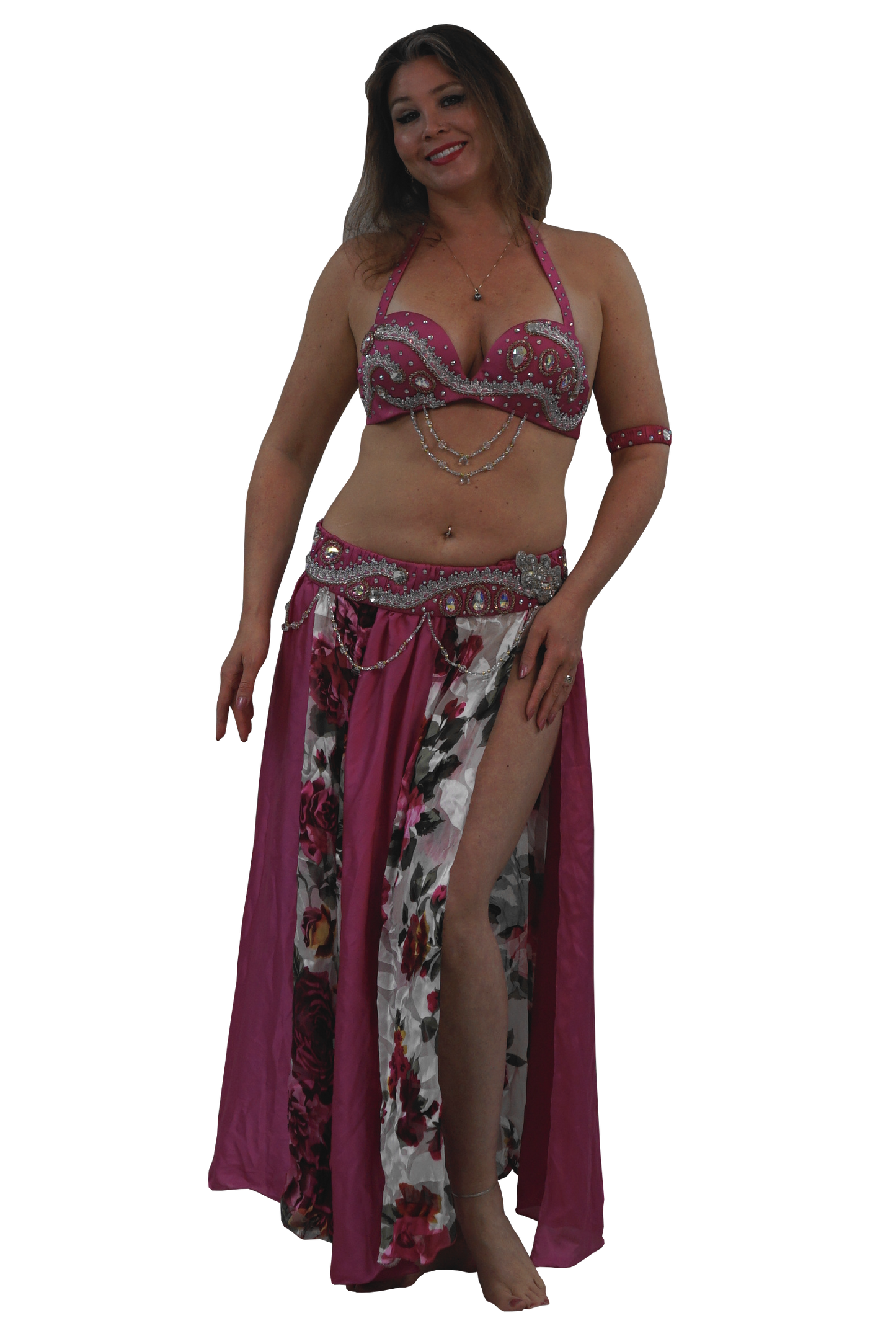 A woman modeling a two-piece belly dancing costume set featuring a pink and silver embellished bra top and a matching floral print skirt with a magenta side panel.