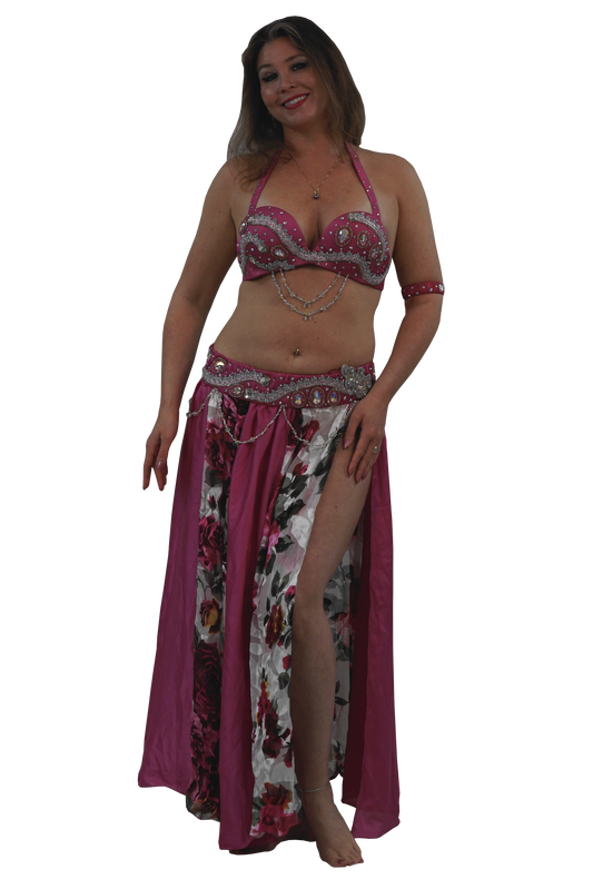 A woman modeling a two-piece belly dancing costume set featuring a pink and silver embellished bra top and a matching floral print skirt with a magenta side panel.