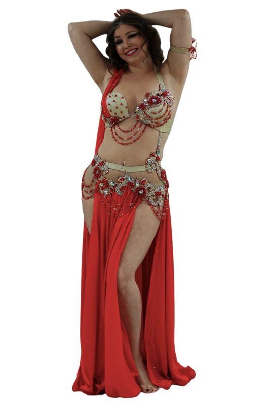 Woman in a rose and gold belly dance costume on a white background