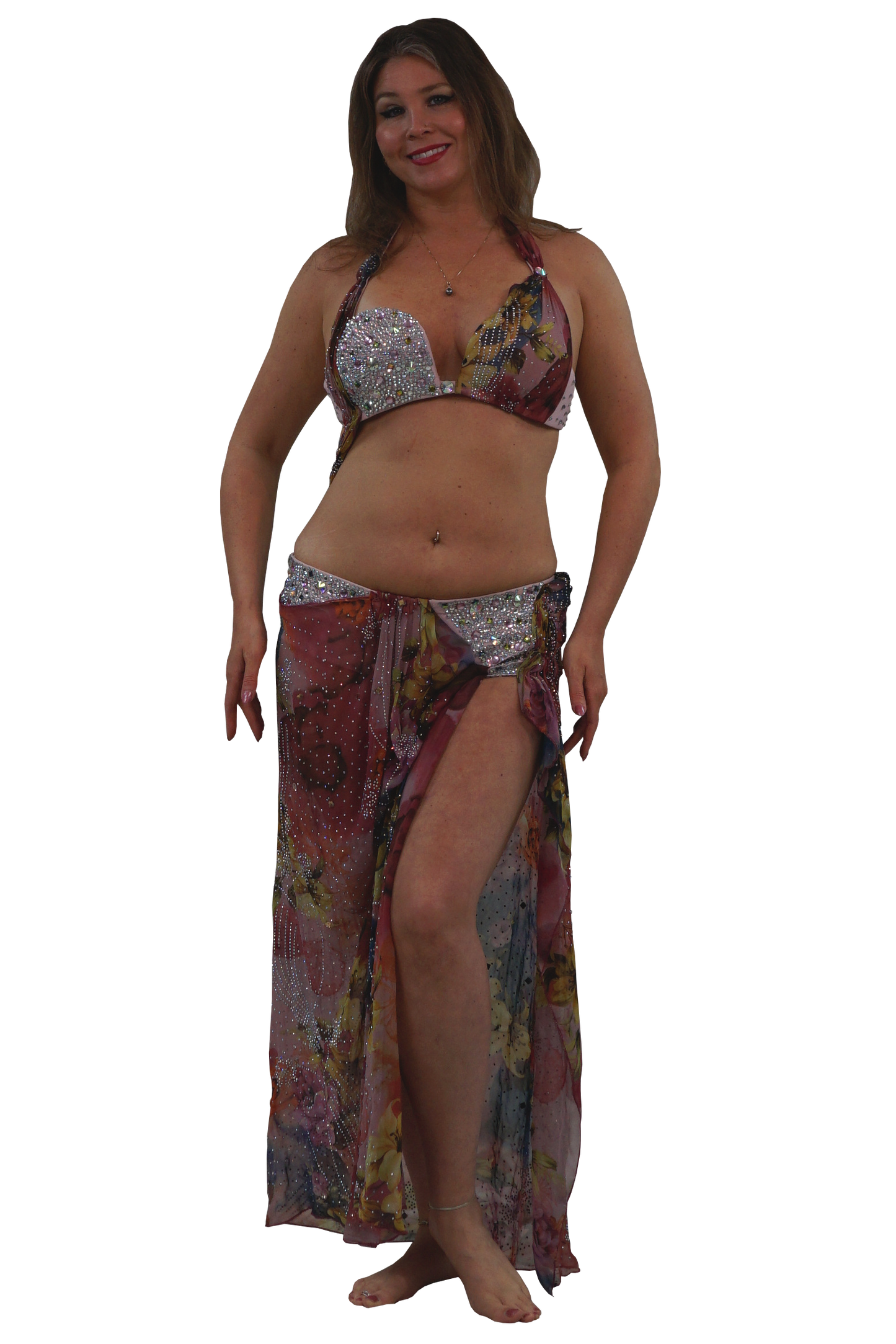 A woman modeling a two-piece belly dance set consisting of a silver sequined bra top and a matching long, sheer sarong skirt with a multicolor floral print.