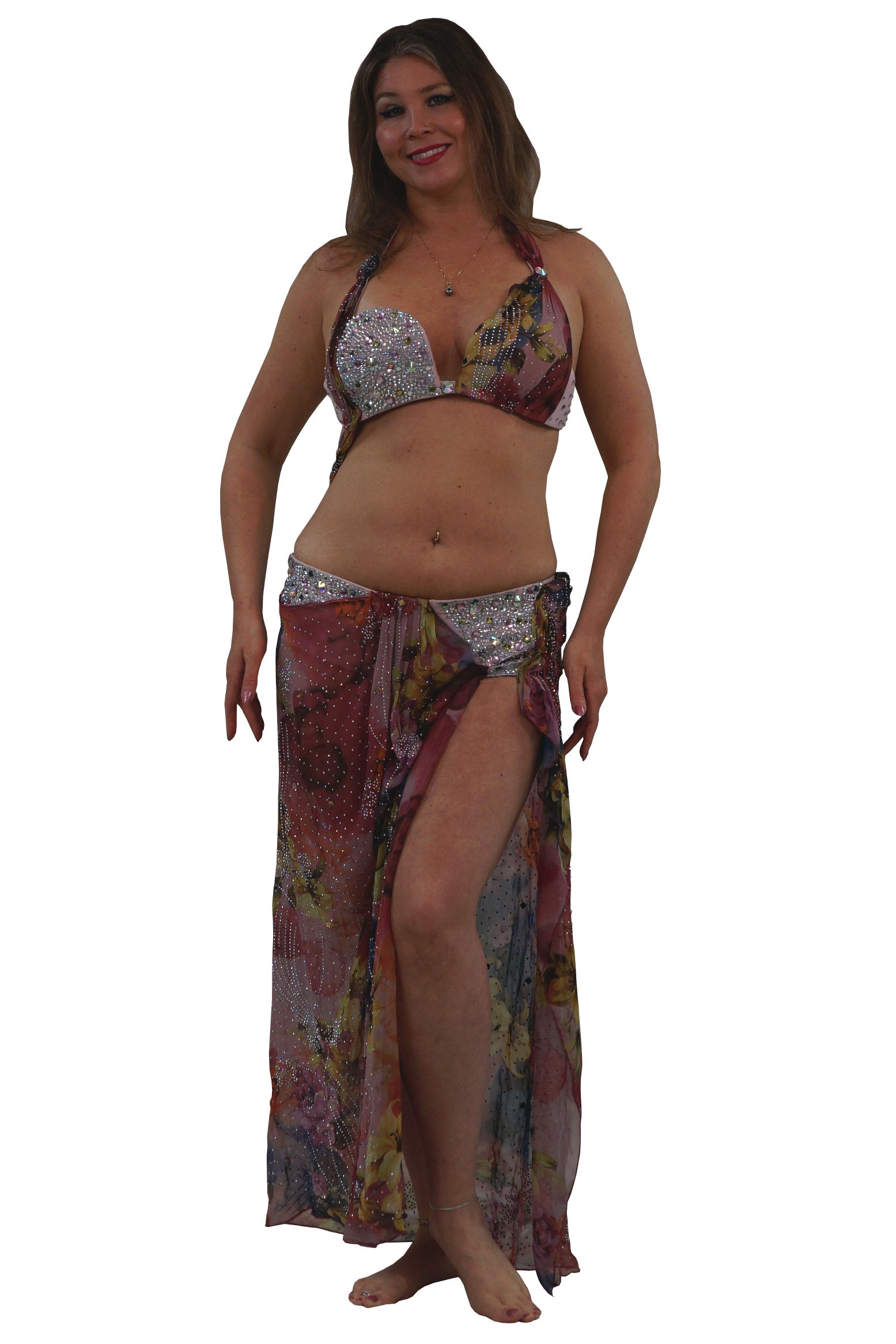 A woman modeling a two-piece belly dance set consisting of a silver sequined bra top and a matching long, sheer sarong skirt with a multicolor floral print.