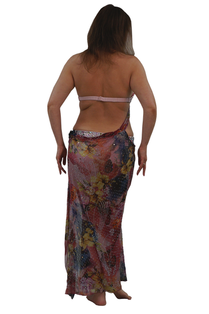 A woman shown from the back wearing a sheer, multicolored floral sarong wrap and a light pink bikini top, isolated on a white background.