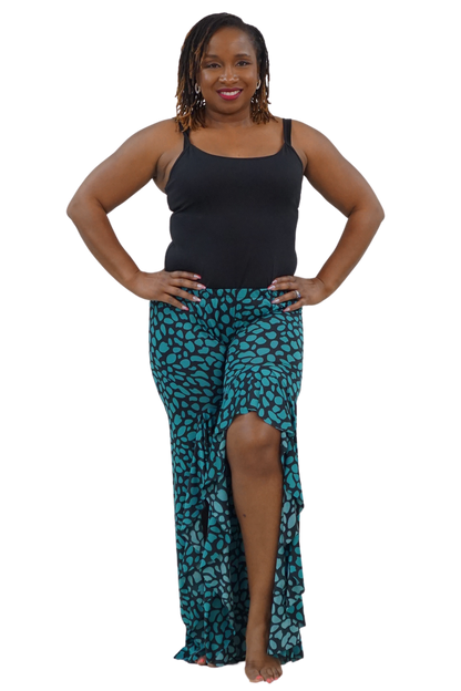 A woman modeling a black sleeveless tank top and a high-low teal and black patterned skirt against a plain white background.